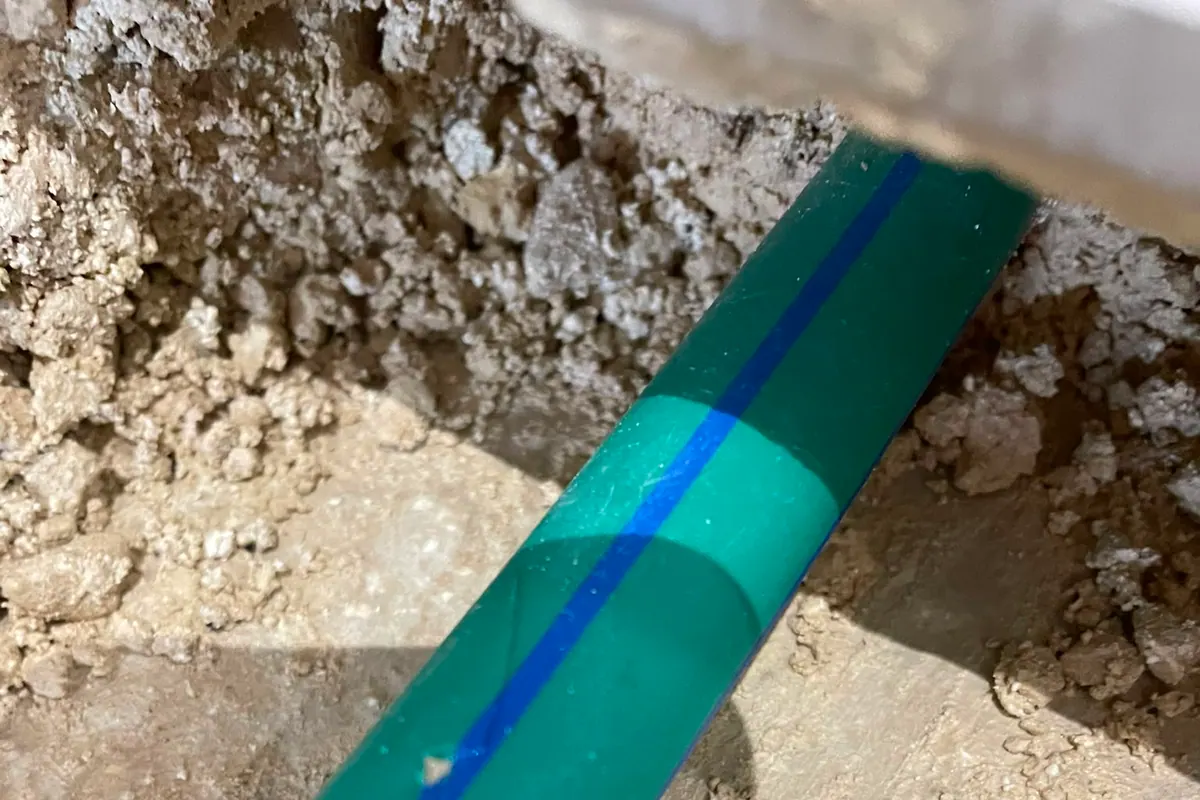Exposed water pipe marked during a leak trace after targeted opening