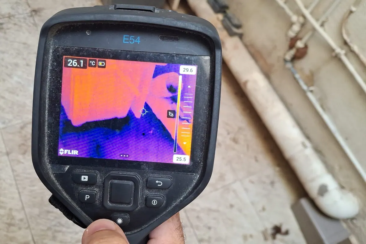 Thermal camera diagnostic screen beside exposed pipework during leak detection